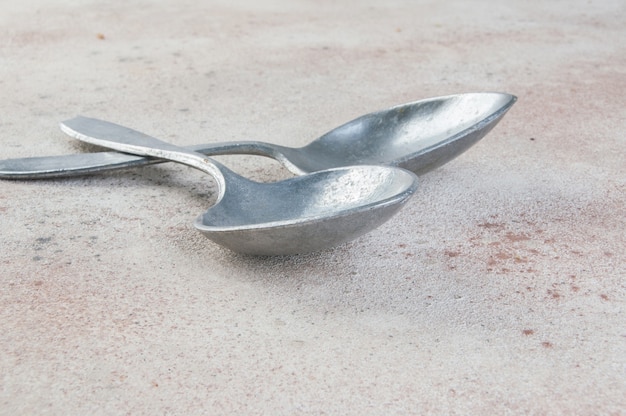 Huge aluminum spoons on concrete background. Copy space for text, food photography props.