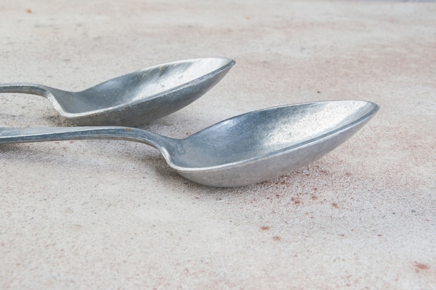 Huge aluminum spoons on concrete background. Copy space for text, food photography props.