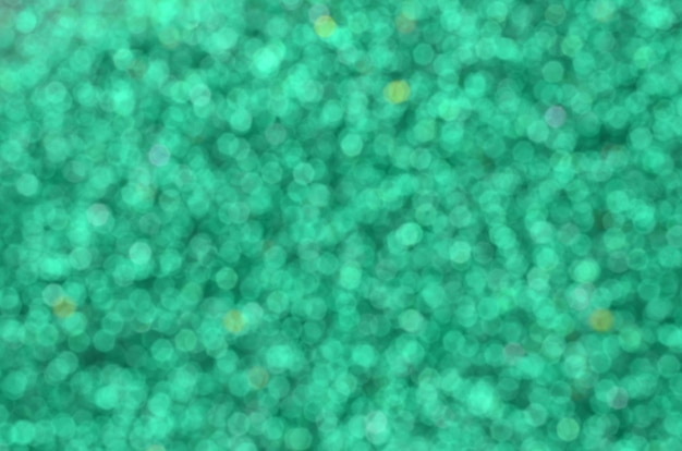 A huge amount of green decorative sequins. Blurred background 