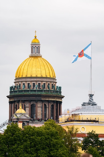 The huge golden dome of St Isaac Cathedral and Admiralty building with flag in St Petersburg