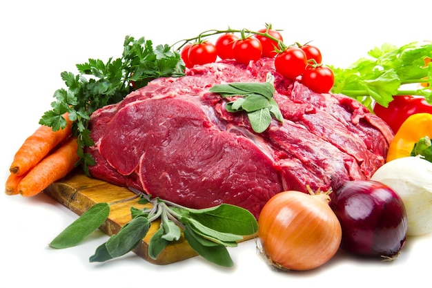 Huge red meat chunk with vegetables isolated over white background