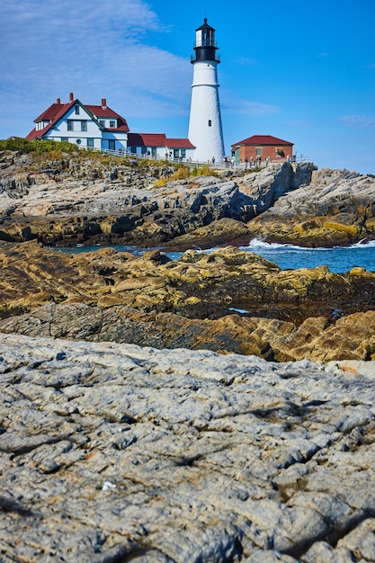 Huge rocky coastline in detail with overlooking white lighthouse