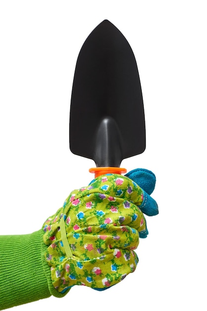 Human hand in a green protective glove holding gardening tool