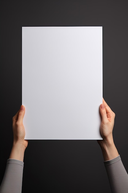 A human hand holding a blank sheet of white paper or card isolated on grey background