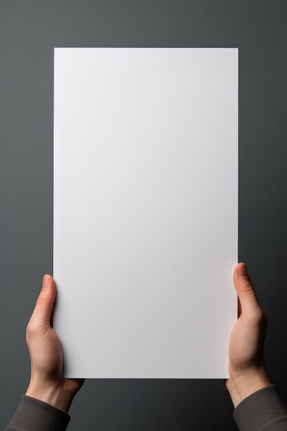 A human hand holding a blank sheet of white paper or card isolated on grey background