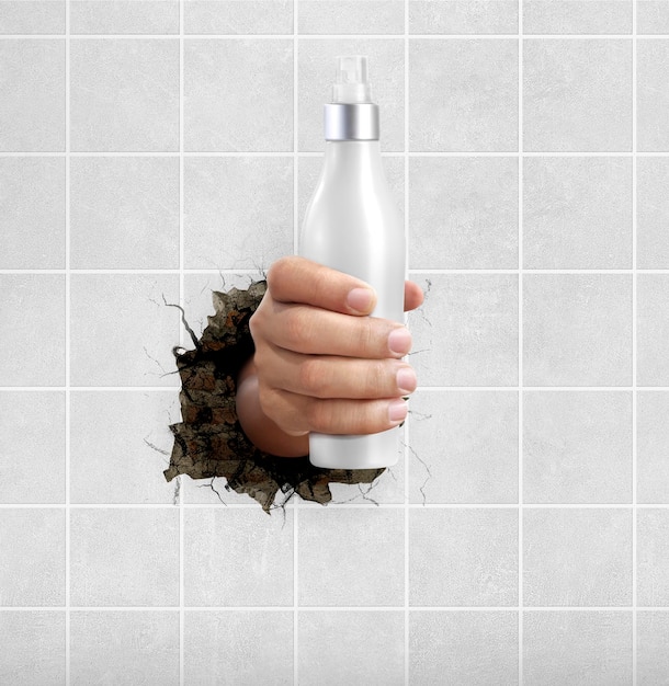 Human hand holding a cosmetics bottle through the wall with cracks