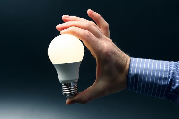 Human hand holds a glowing led lamp