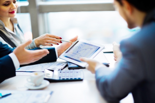 human hand pointing at touchscreen in working environment at meeting