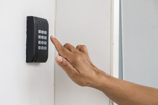 Human hand presses on the button, entering security system code. Combination PIN code on k