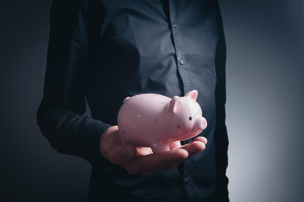 Human hand protecting a piggy bank