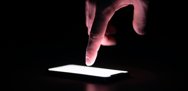 A human hand touching the screen and push the button on mobile device