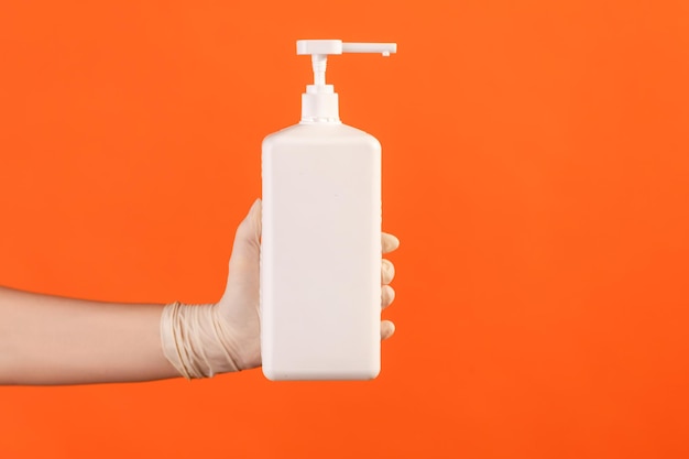 Human hand in white gloves holding and showing sanitizer, antiseptic or anti bacterial soap