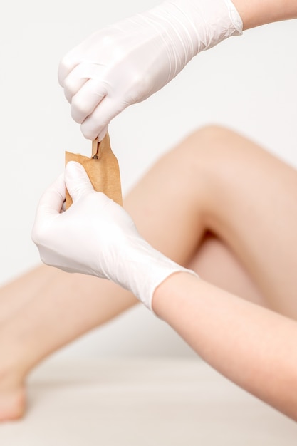 Human hands in protective gloves holding craft envelope with medical or beauty tools