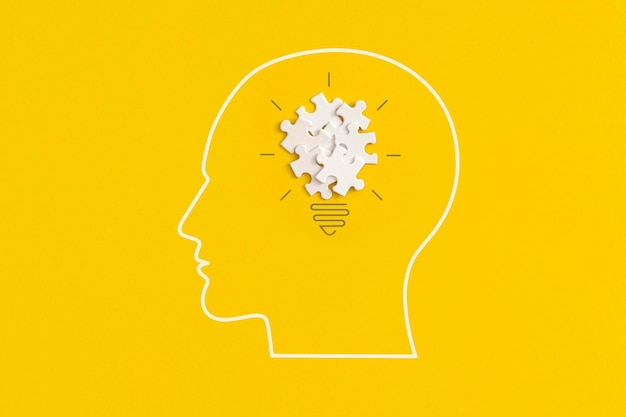 Human head with lightbulb on yellow background