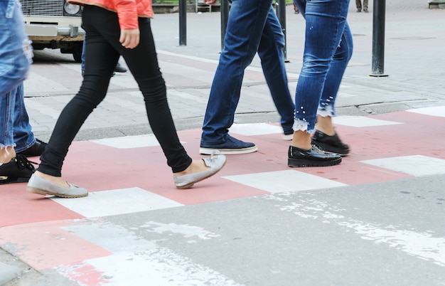 Human legs are moving on a pedestrian crossing