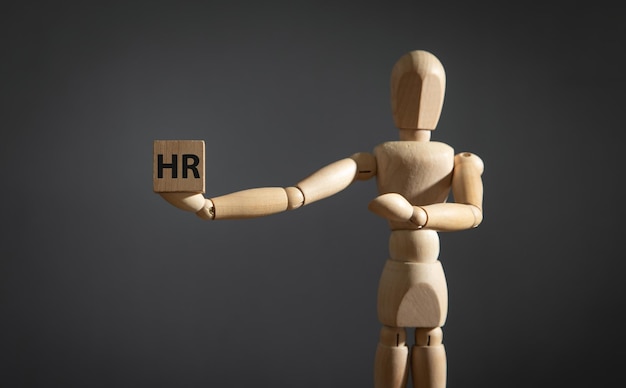 Human wooden figure showing HR word on wooden cube