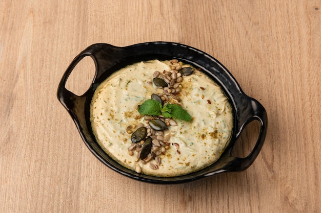 Hummus Bayroute served in dish isolated on table top view of arabian food