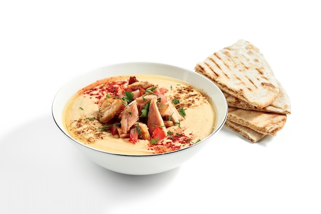 Hummus with chicken and pita in a pita bowl isolated on a white background