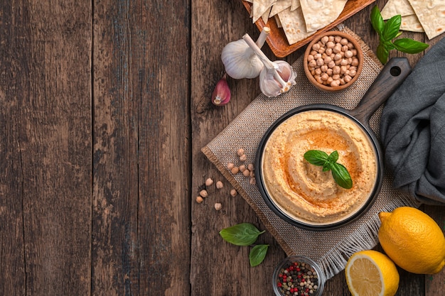 Hummus with sesame garlic and lemon on a wooden background