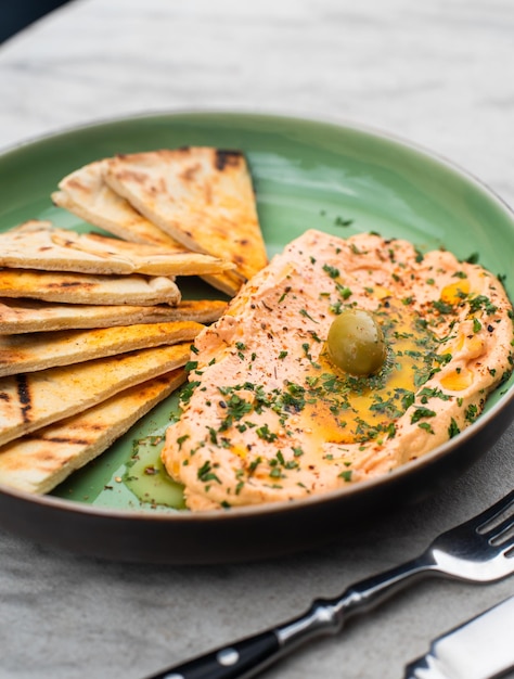 Hummus with spicy herbs olive oil and cakes traditional Eastern food