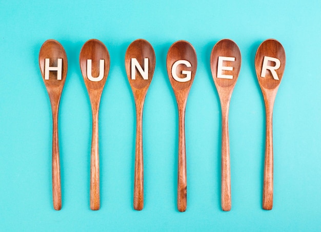 Hungry is standing in german language on the wooden spoons, food shortage and starving