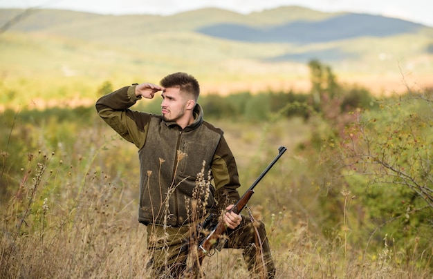 Hunter hold rifle Focus and concentration of experienced hunter Hunting and trapping seasons Man brutal gamekeeper nature background Hunting permit Bearded hunter spend leisure hunting