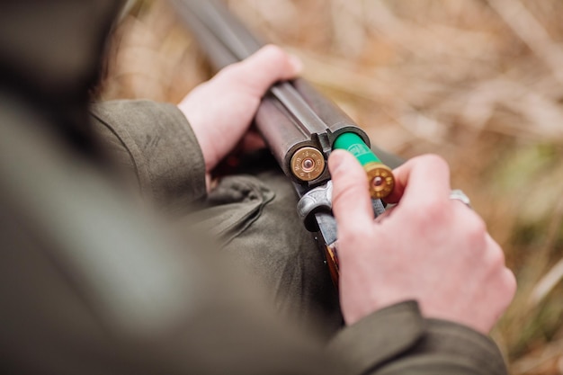 Hunter loading rifle in a winter forest Bushcraft hunting and people concept