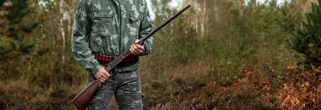 Hunter man in camouflage with a gun during the hunt