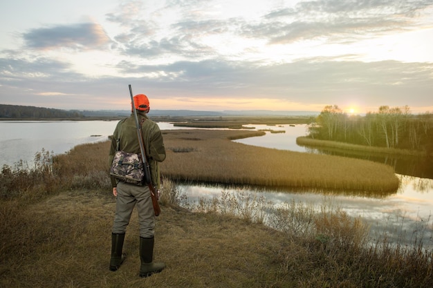 Hunter in season autumn at sunrise Hunter with a gun hunting on ducks