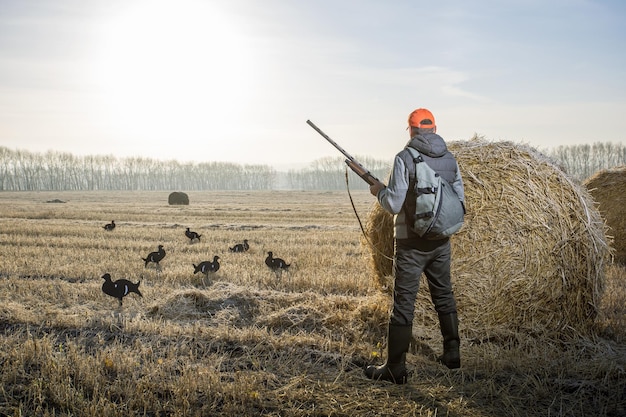 Hunter with a gun hunting on birds in autumn season Male hobby concept