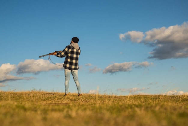 Hunter with shotgun gun on hunt. Illegal Hunting Poacher in the Forest. Hunting is the practice of killing or trapping animals.