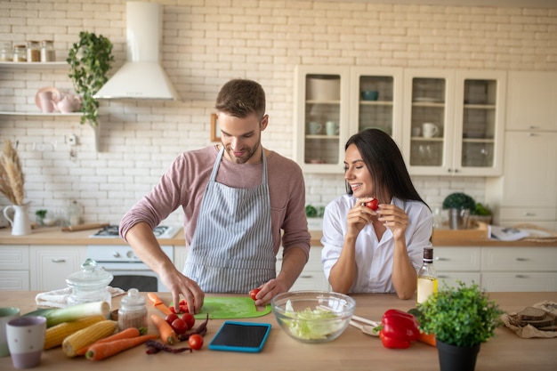 Husband cooking Wife wearing white shirt coming to husband cooking in the morning