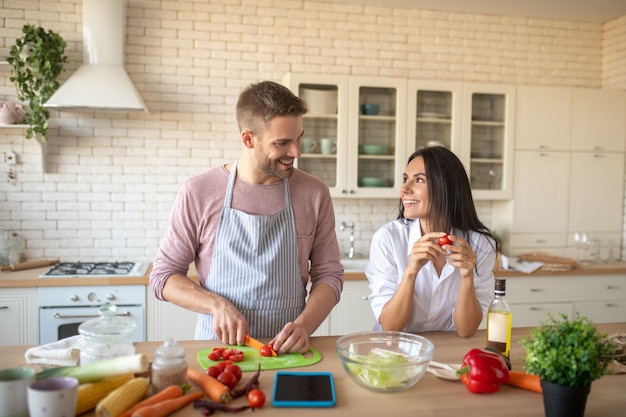 Husband cooking Wife wearing white shirt coming to husband cooking in the morning