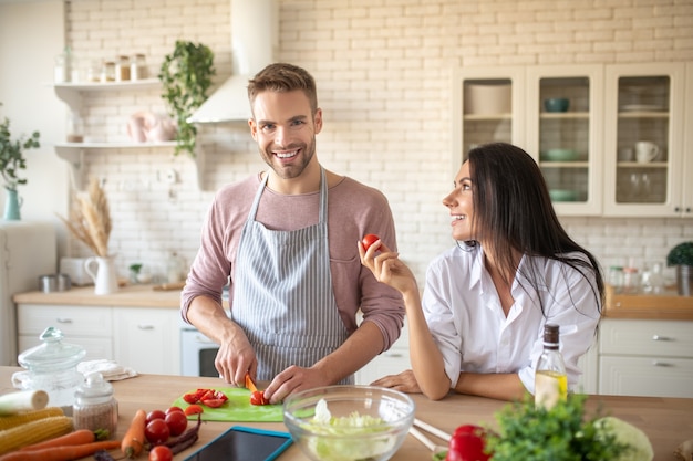 Husband cooking Wife wearing white shirt coming to husband cooking in the morning