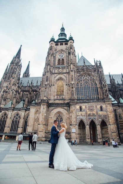 Husband and wife are holding hands at sunset in Prague