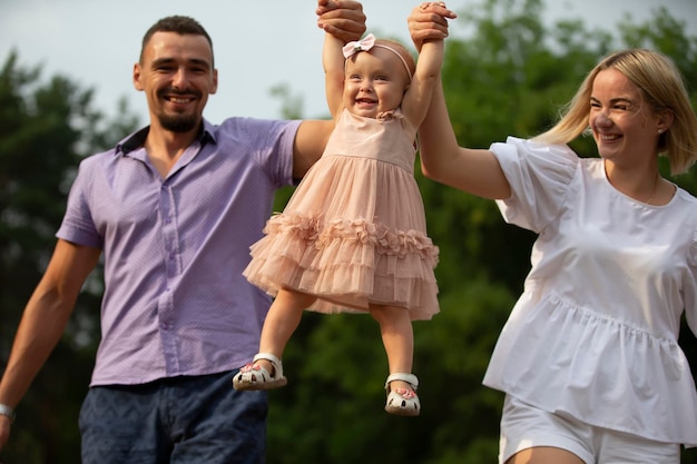 Husband wife and their little daughter for a walk in the park