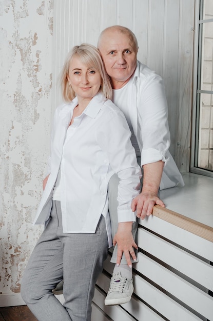 husband and wife in white shirts hug and kiss