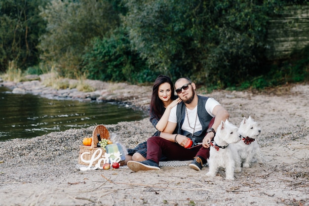 Husband with a beautiful wife walking their white dogs in the park