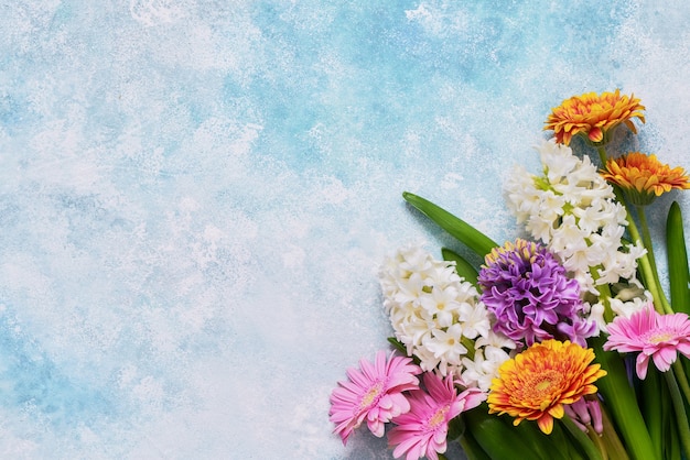 Hyacinth and gerbera flowers bouquet on blue. Top view, copy space. Mothers Day, Birthday