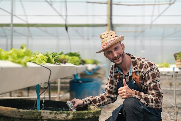 Hydroponics vegetable farm male farmer checking vegetables from his hydroponics farm concept of growing organic vegetables and healthy food