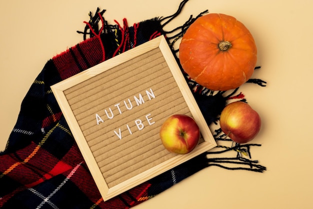 Hygge Style Autumn Flat Lay with Woolen Scarf Red Apples and Pumpkin and Letter Board