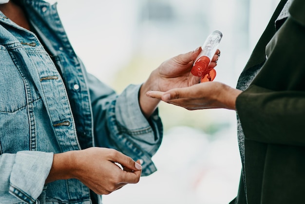 Hygiene covid and cleaning with healthy woman applying hand sanitizer during a quarantine Medical health and safety as black adults clean their hands to stop the spread of covid at a clinic