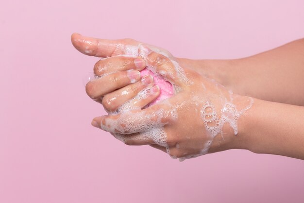 Hygiene to protect human health from viruses hand washing with soap process On pink