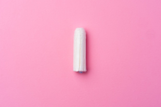 Hygienic female tampon on a pink background top view