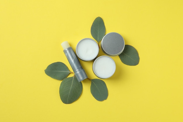 Hygienic lipstick and lip balm on yellow background