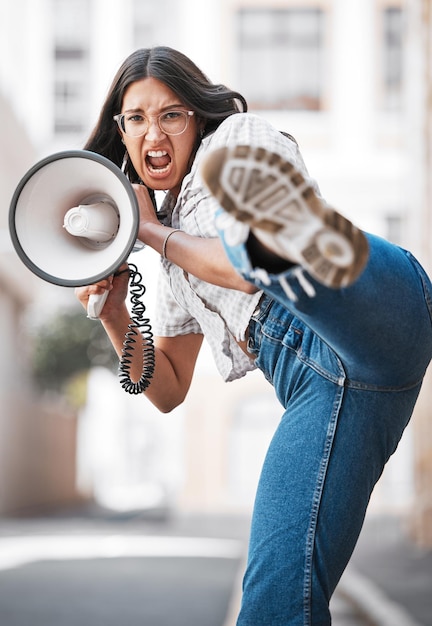 I am a woman Phenomenally Phenomenal woman Shot of a young woman screaming into a loud speaker while protesting in the city