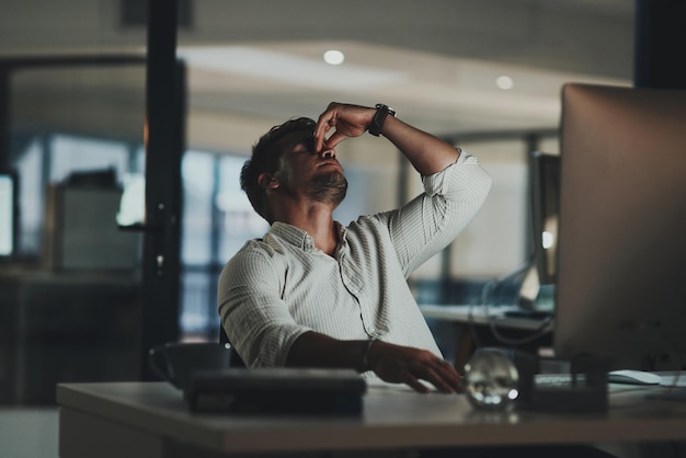 I just cant focus Shot of a young businessman looking stressed out while working on a computer in an office at night