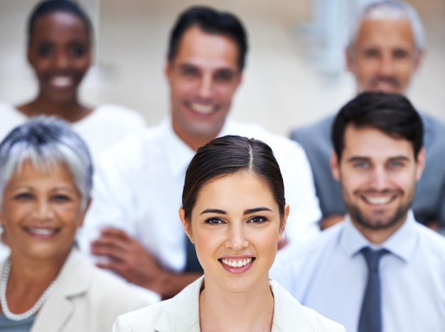 I lead by example Portrait of a smiling businesswoman surrounded by a group of her colleagues