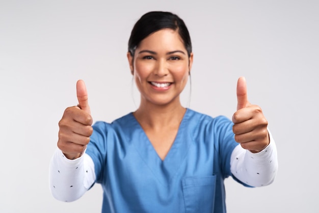 I live where soul meets body Portrait of a young doctor showing a thumbs up sign against a white background