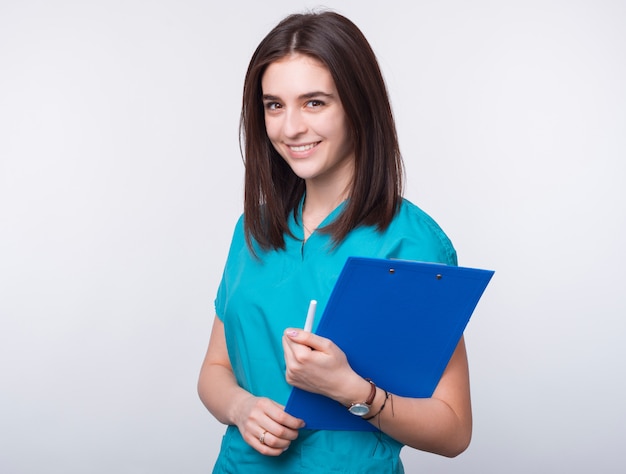 I love being a doctor. Portrait of a young female smiling and  holding paper board on white space.